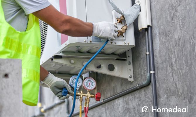 Tecnico specializzato durante l’installazione di un condizionatore a parete con strumenti di controllo pressione - Homedeal
