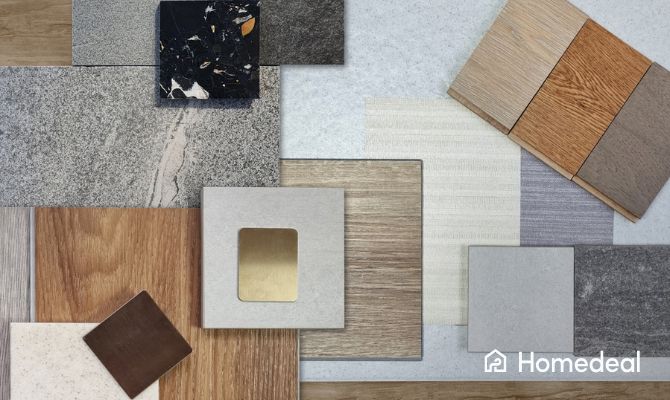 Campioni di materiali e superfici per il bagno disposti su un piano: piastrelle in gres, legno, laminato, marmo e metallo in diverse texture e tonalità neutre. Immagine ispirazionale per la scelta di rivestimenti e pavimentazioni. Logo Homedeal nell'angolo in basso a destra.