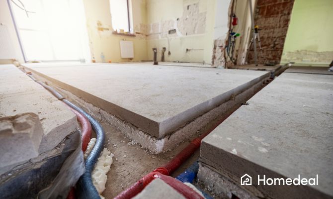 Strato isolante posato sotto pavimento in cemento durante lavori di ristrutturazione con impianti a vista – isolamento termico pavimento con posa professionale. - Homedeal
