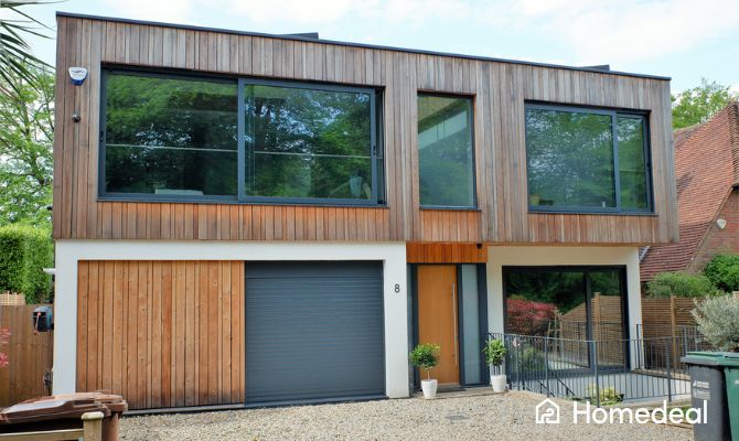 Casa moderna con facciata in legno naturale e infissi esterni in alluminio antracite, esempio elegante di abbinamento colori infissi esterni in stile contemporaneo - Homedeal