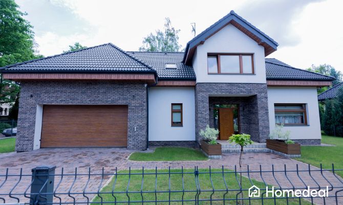 Villa moderna con facciata in mattoni grigi e intonaco bianco, abbinata a infissi color legno e portone coordinato, esempio di abbinamento colori facciata e serramenti in stile contemporaneo - Homedeal