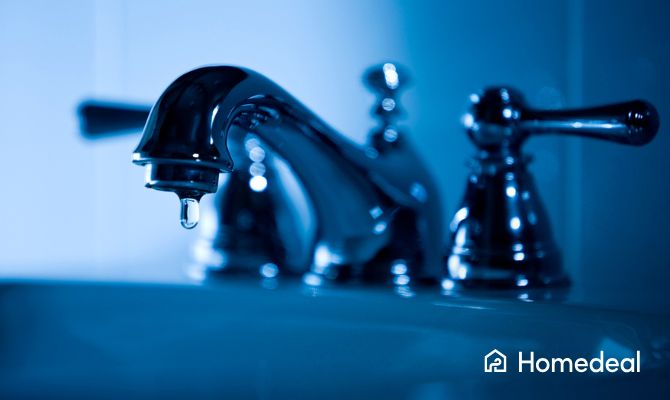 Rubinetto che perde con una goccia d'acqua visibile, simbolo di perdita e spreco idrico, in primo piano su lavandino scuro - Homedeal