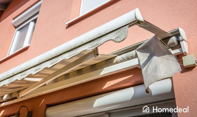 Telo di tenda da sole danneggiato e scolorito su una facciata esterna, pronto per la sostituzione – Homedeal