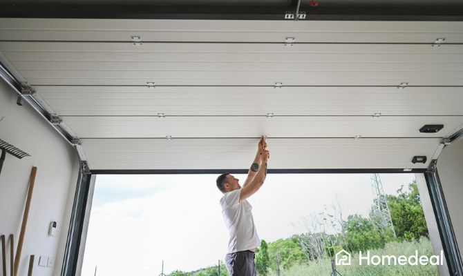Uomo che apre o chiude una porta garage sezionale automatizzata, visto dall’interno del garage - Homedeal